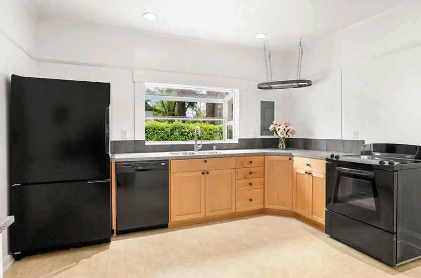 L shaped kitchen with garden window black appliances