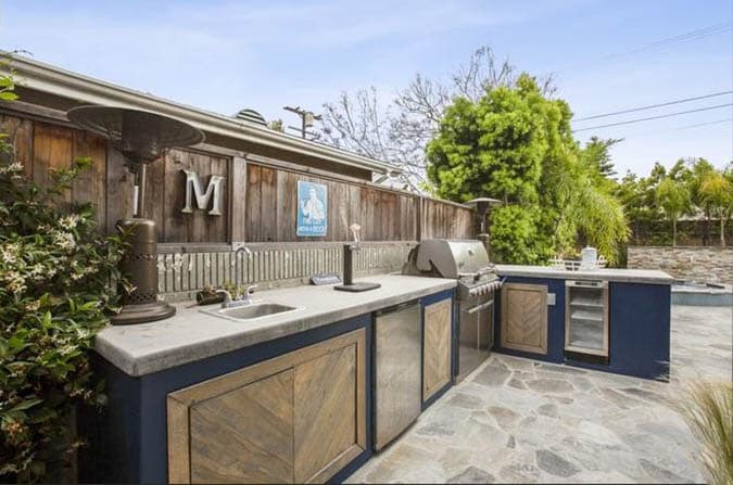 L shaped outdoor kitchen with concrete countertop