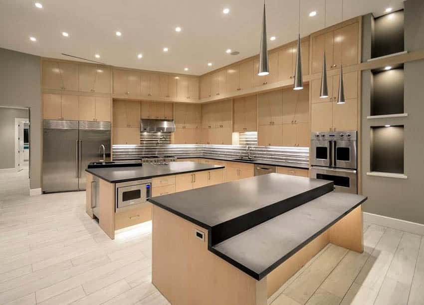Modern kitchen with matte black quartz countertops light brown cabinets and pendant lights