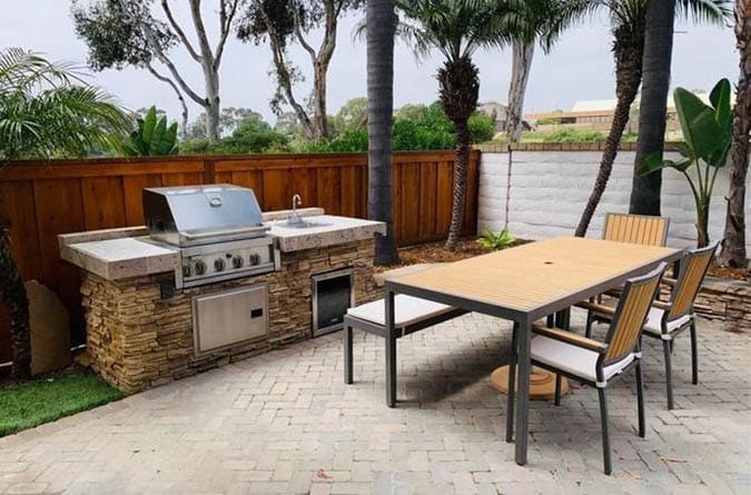 Outdoor kitchen with concrete counter and stacked stone