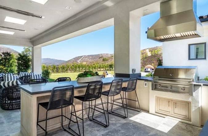Outdoor kitchen with concrete countertop and bar seating