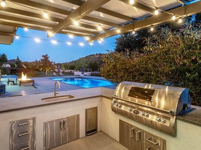 Outdoor kitchen with concrete countertops and pergola