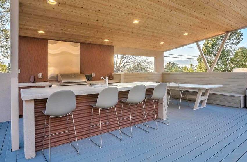 Outdoor kitchen with concrete countertops corrugated side island and covered patio