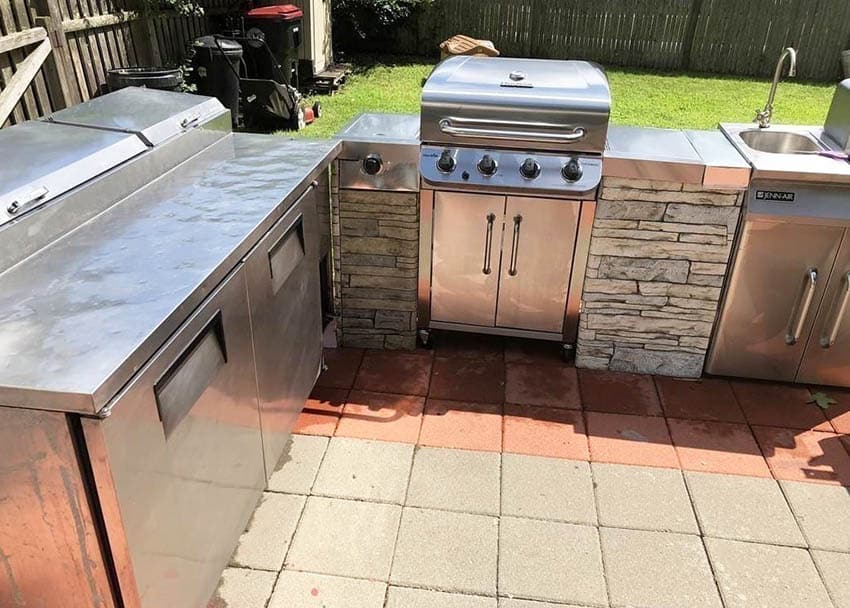 Outdoor kitchen with stainless steel countertops and stacked stone sides