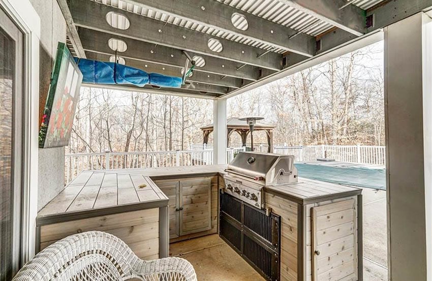 Outdoor kitchen with wood countertop covered patio