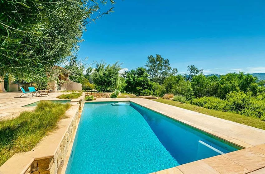 Swimming pool with stone retaining wall on hill