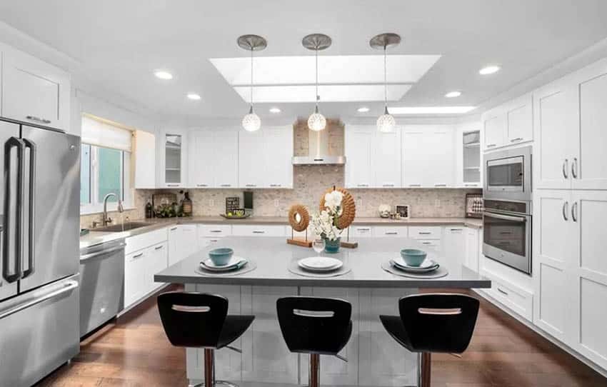 U shaped kitchen with skylights white cabinets gray quartz island