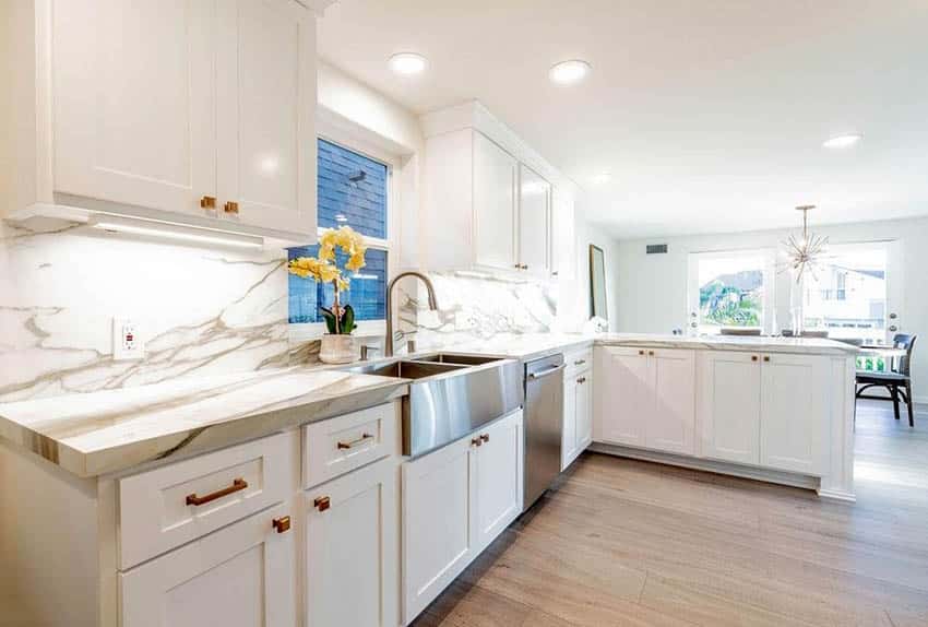 White cabinet kitchen with porcelain countertops and backsplash