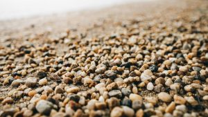 Close up of smooth tan and gray pea gravel ground cover