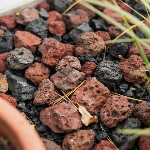 Red and black porous lava rock spread as landscaping ground cover