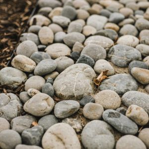 Smooth rounded river rocks in mixed gray and tan natural tones