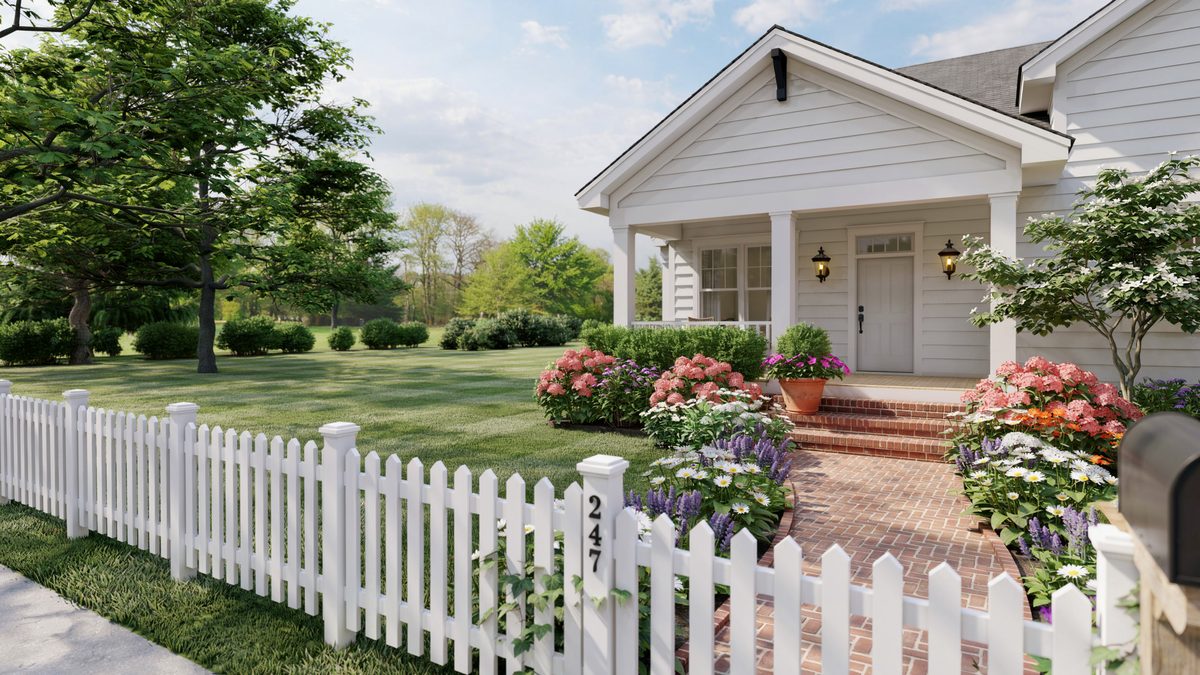 White cottage behind picket fence with blooming borders and brick steps