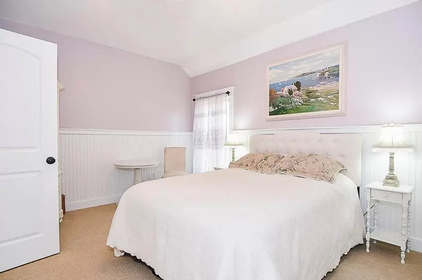 Bedroom with pink paint and white wainscoting