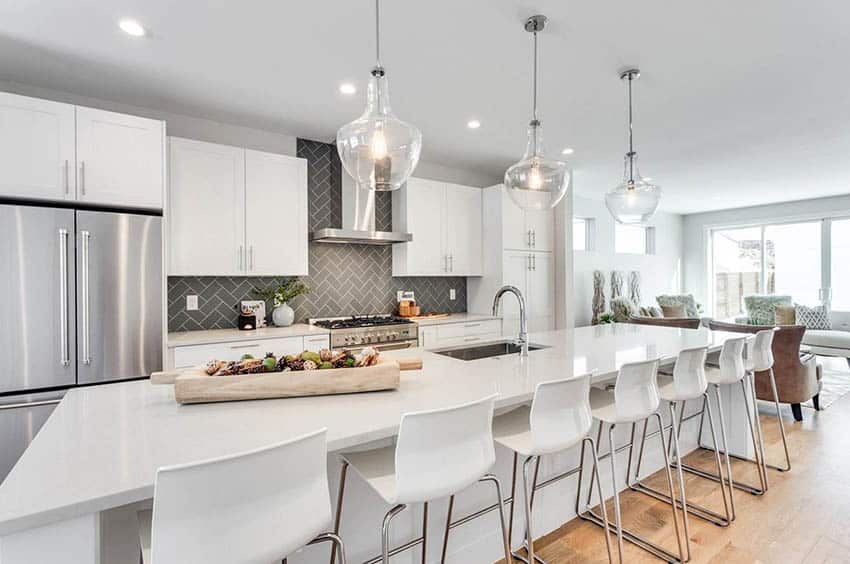 Kitchen with long island and herringbone pattern backsplash