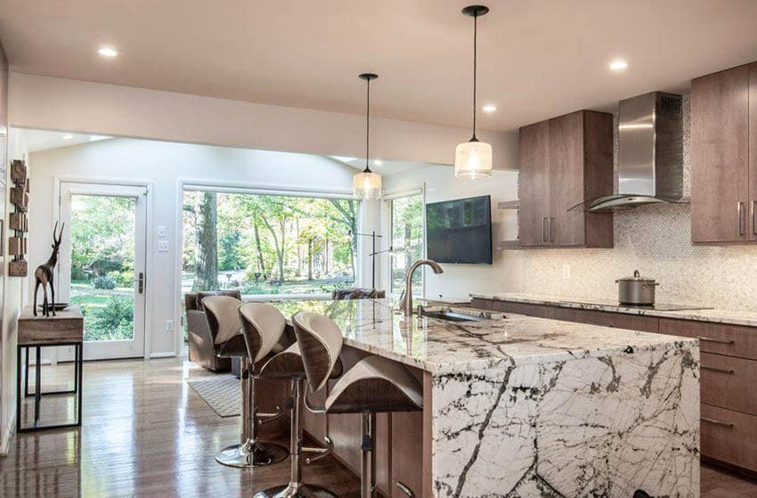 Kitchen with waterfall style countertop in quartz material and brown base 