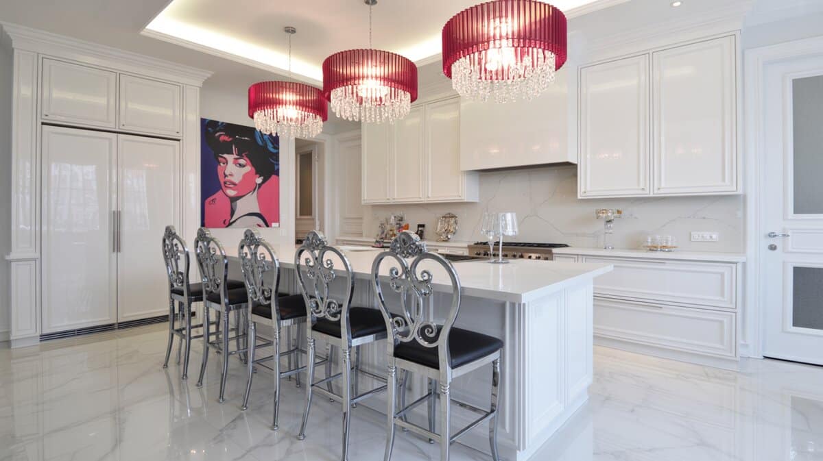 Glamorous white kitchen with chrome scroll stools, red crystal pendants, and marble floors