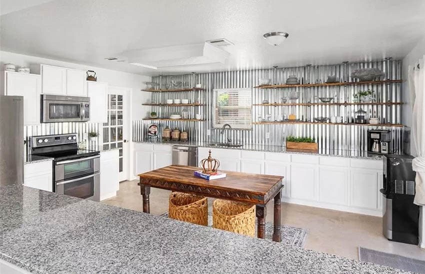Kitchen with corrugated galvanized steel wall backsplash white cabinets and granite countertops