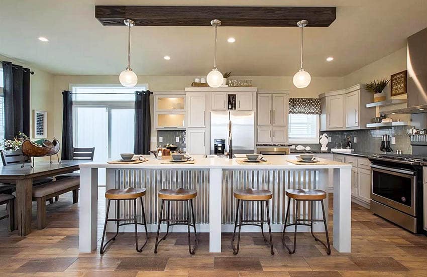Kitchen with corrugated metal island, white cabinets and pendant lights
