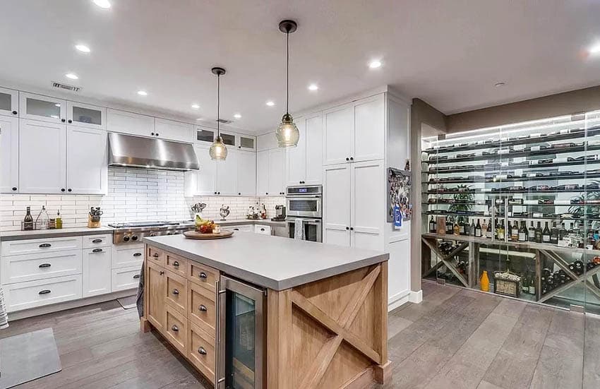 Kitchen with glass wine closet, white cabinets and wood island