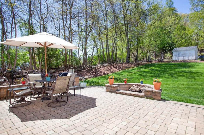 Large paver patio with rustic semi circle fire pit