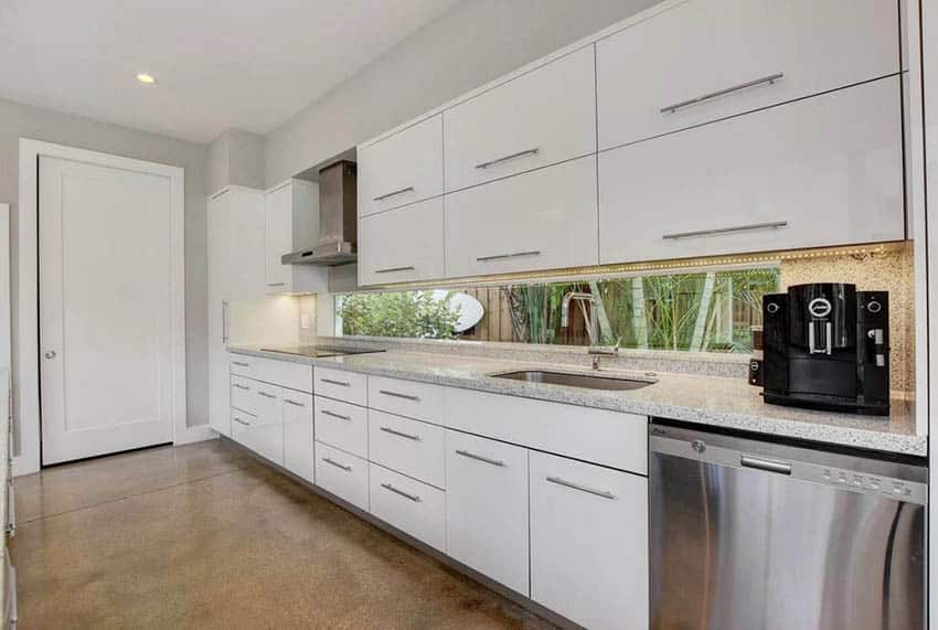Modern galley kitchen with under cabinet rope lighting, white cabinets and quartz countertops
