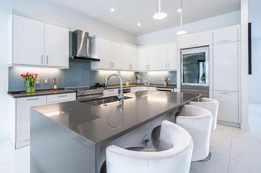 Modern kitchen with under cabinet lighting white gloss cabinets gray quartz countertops