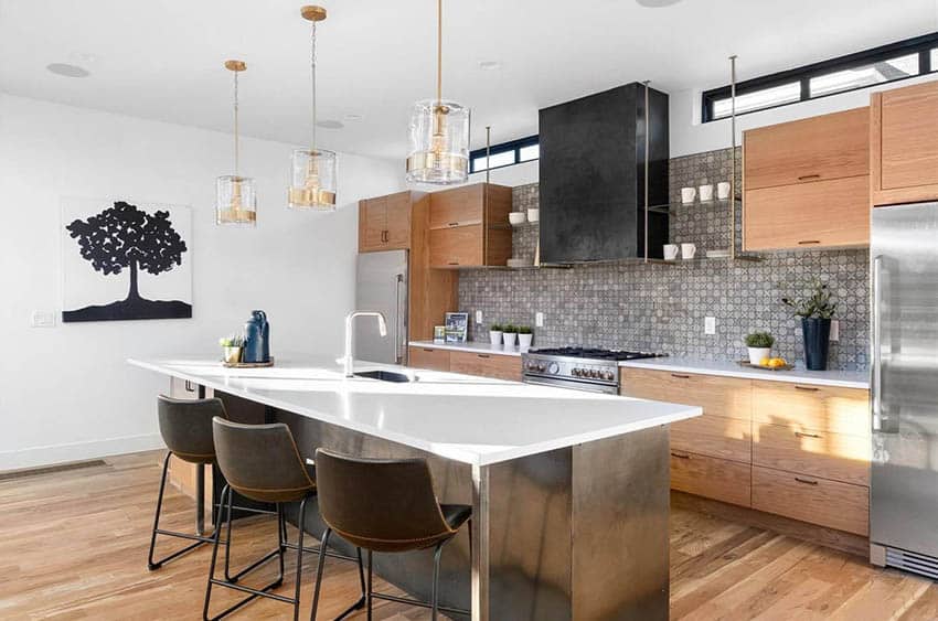 Kitchen with wood veneer cabinets, white quartz counters, gray tile backsplash and pendant lighting