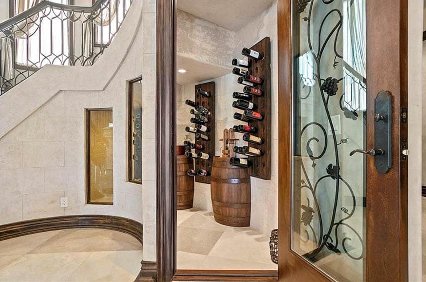 Rustic wine closet under stairs with decorative glass, wood and wrought iron door