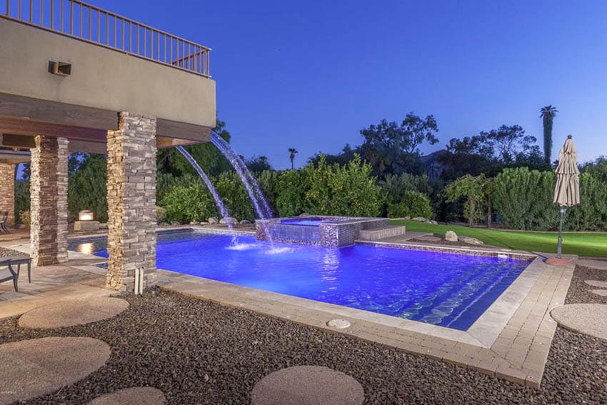 Swimming pool with paver walkway patio and gravel landscape elevated hot tub