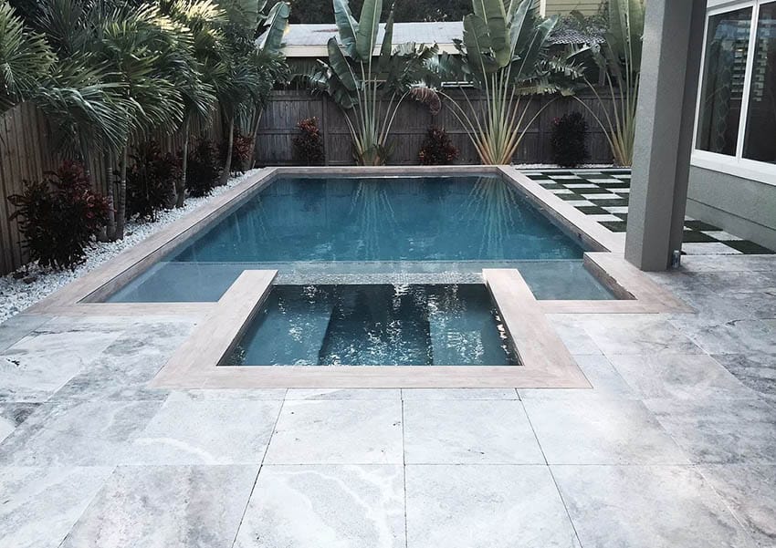 Tumbled marble paver patio beside swimming pool
