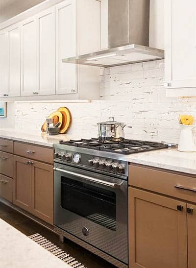 Two tone kitchen cabinets with stainless steel stove