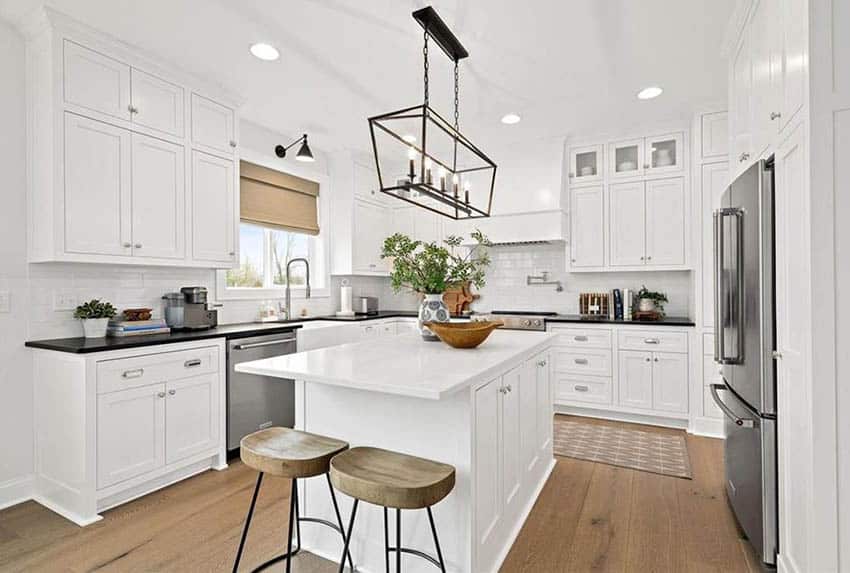 White kitchen with island seating on end for two bar stools