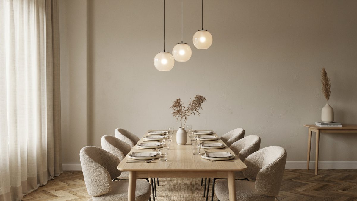 Three frosted globe pendants glowing over a pale oak table set for six