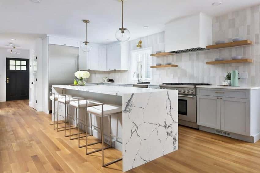 Contemporary kitchen with quartz countertops, white cabinets and globe lighting over island