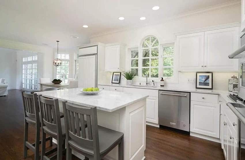 Corner kitchen with white cabinets cultured marble countertops and island