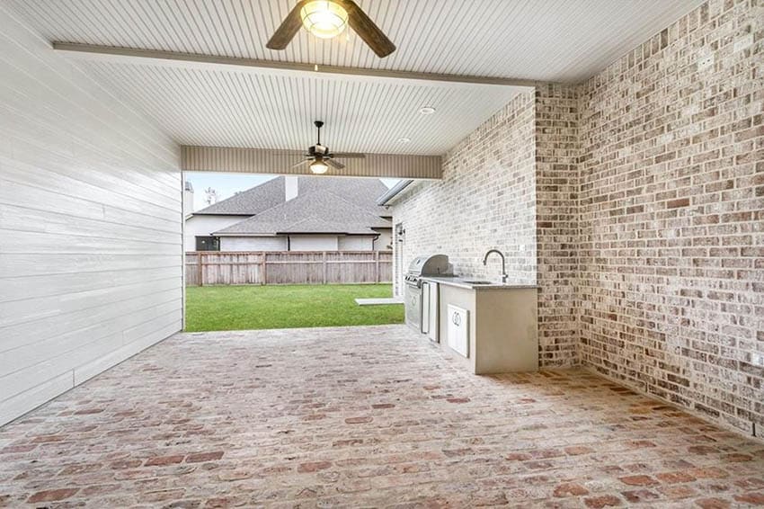 Covered patio with brick floor and outdoor kitchen