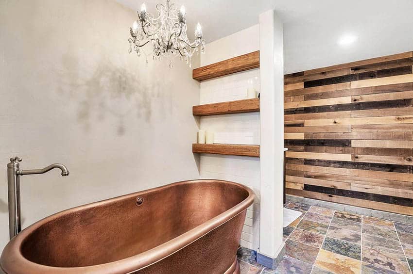 Freestanding copper tub in bathroom with wood accent wall