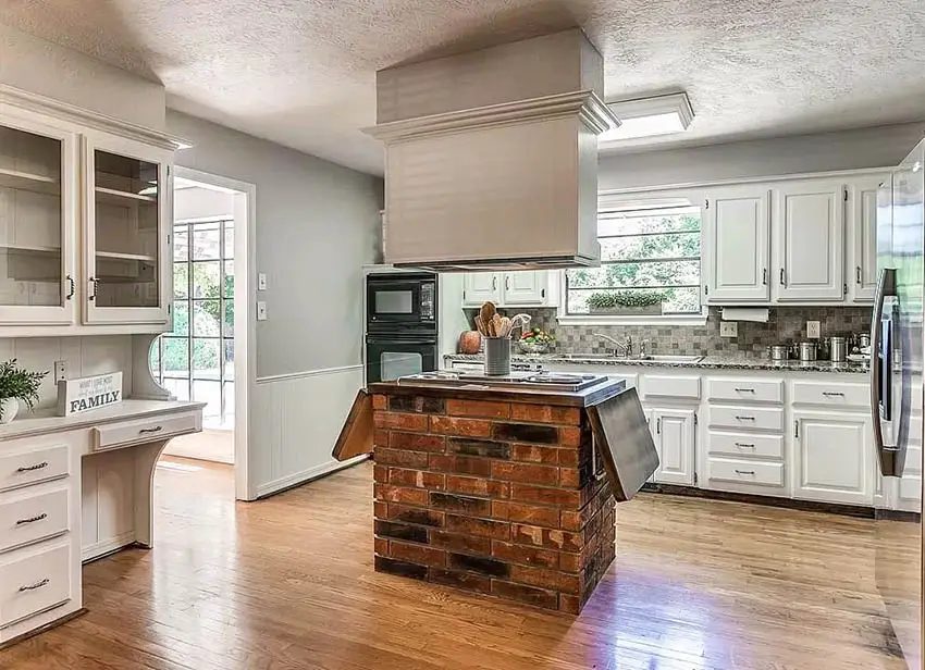Kitchen with brick island stove top and oven hood
