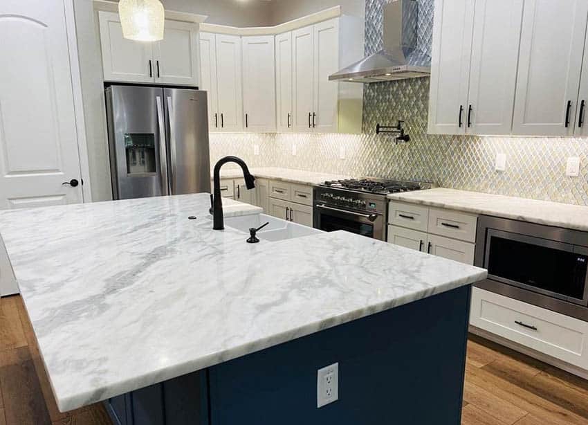 Kitchen with cultured marble countertops white cabinets blue island
