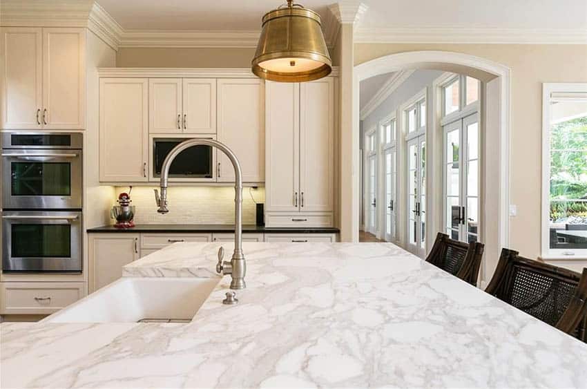 Kitchen with marble countertop island white cabinetry