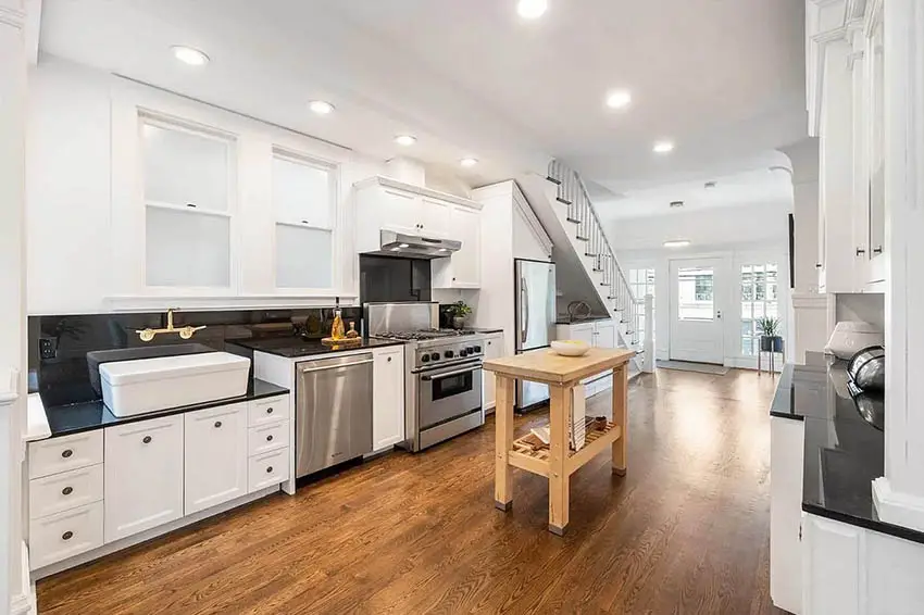 Kitchen with storage below staircase and portable wood island