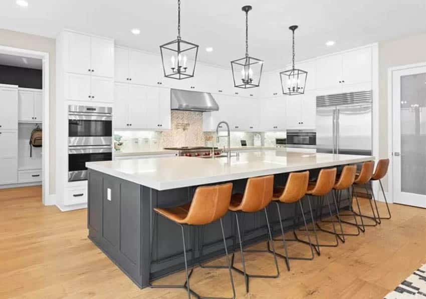 Kitchen with white quartz countertops gray island white cabinets wood floors