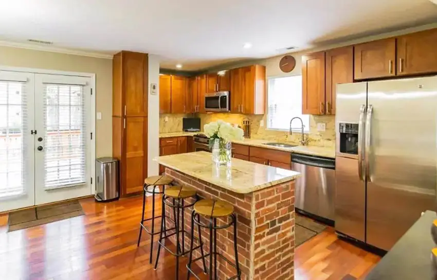 L shaped kitchen with brick island wood cabinets