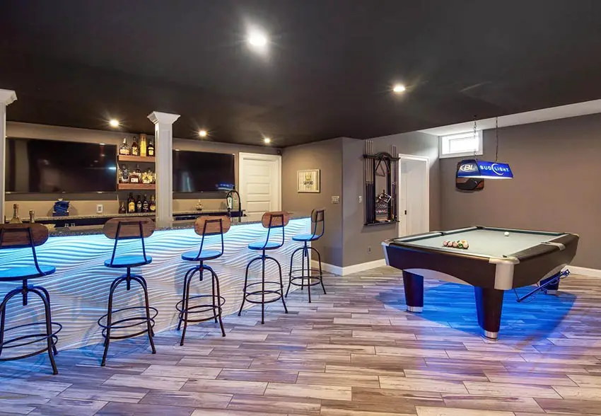 Modern basement game room with home bar and wood plank flooring