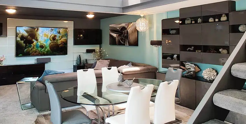 Modern basement living room with teal walls glossy cabinet storage