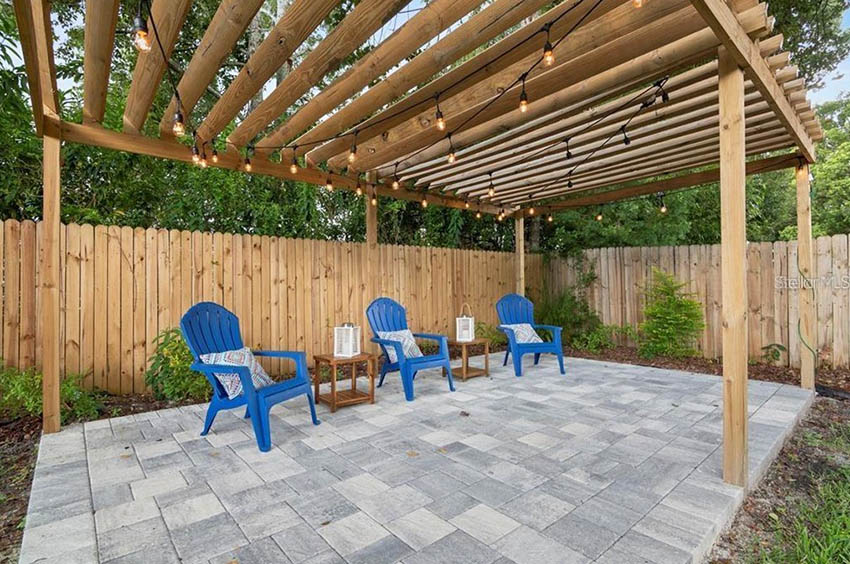 Natural stone paver patio with wood pergola and hanging lights