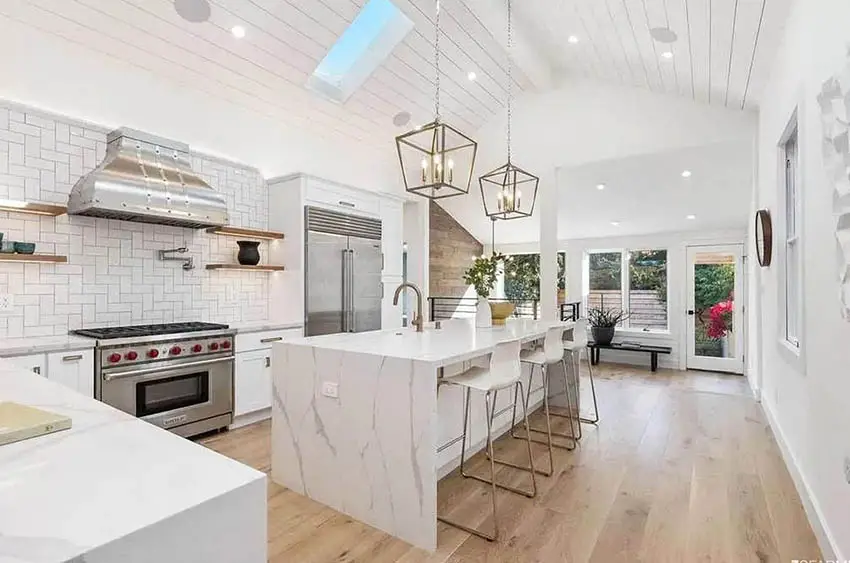 Open island kitchen with skylight shiplap ceiling