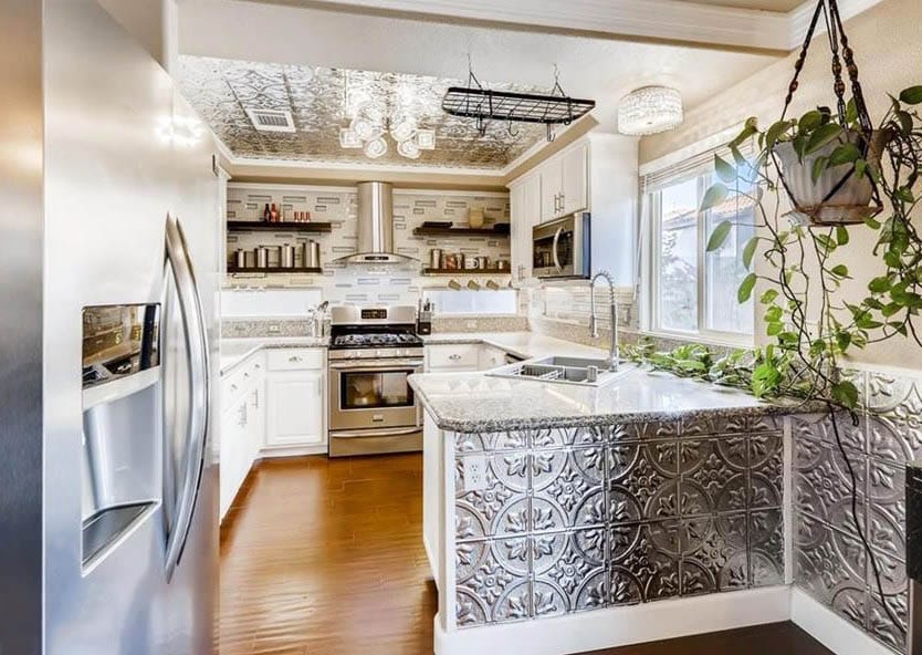 Traditional kitchen with tin ceiling tin peninsula and walls with white cabinets