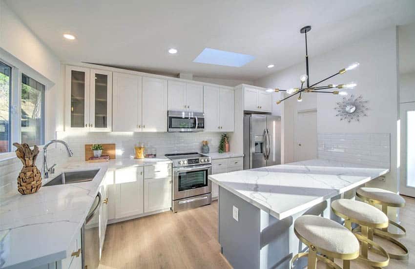 Transitional kitchen with skylight white cabinets quartz countertop and subway tile backsplash