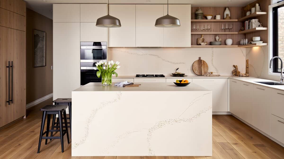 Modern white quartz waterfall island with black pendants and open shelving